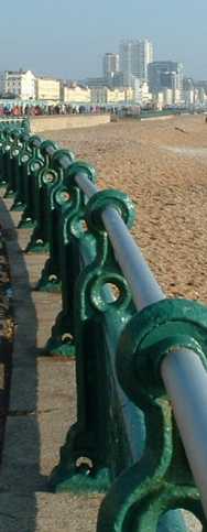 green brighton iron railing spiralling along hazy beach front
